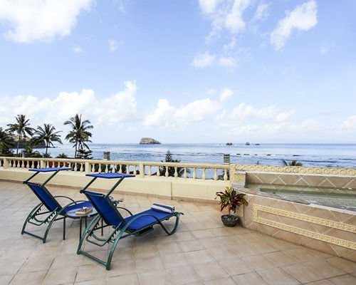 Balcony with chaise lounge chairs and sea view.