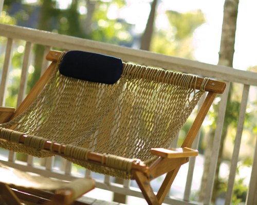 A CLOSE UP OF PORCH SEATING WITH PILLOW.