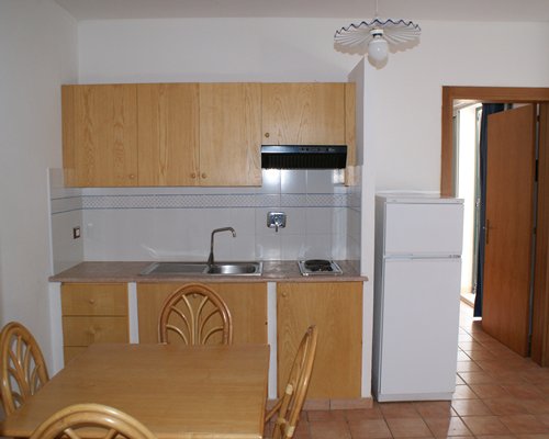 A well equipped kitchen with a wooden dining area.