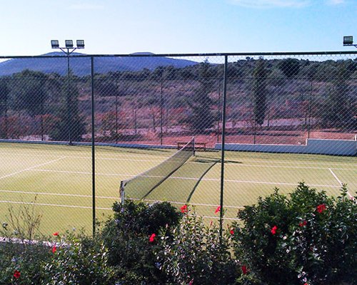 An outdoor tennis court with trees.