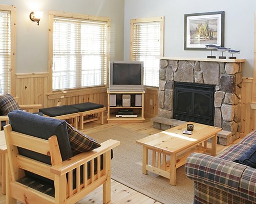 A well furnished living room with a television pull out sofa fireplace and an outside view.