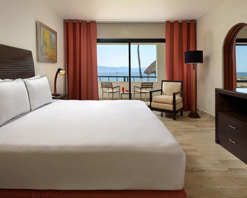 A well furnished bedroom with king bed and a television.