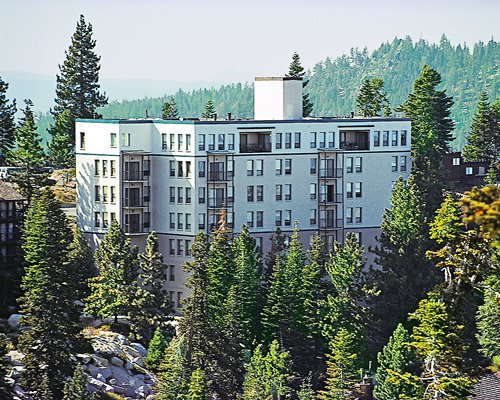Exterior view of Vacation Internationale Kingsbury Of Tahoe resort surrounded by wooded area.
