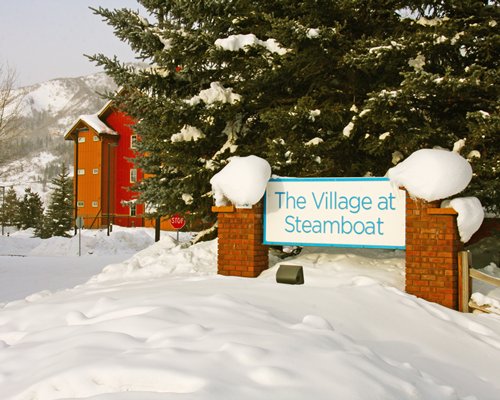 Signboard of the resort covered in snow.