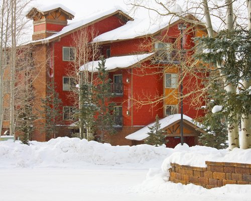 Exterior view of a unit with balcony covered with snow during winter.