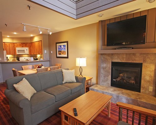 An open plan living room with a television fireplace dining and kitchen area.