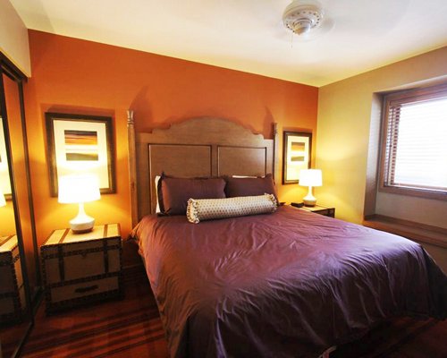 A well furnished bedroom with king bed and outside view.
