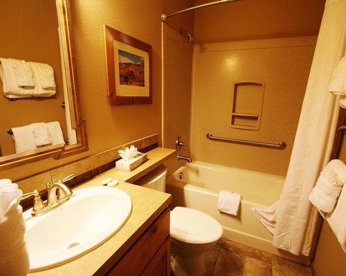A bathroom with a single sink vanity and bathtub.