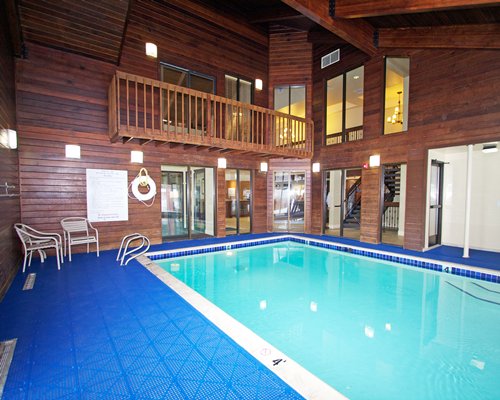 An indoor swimming pool with patio furniture.