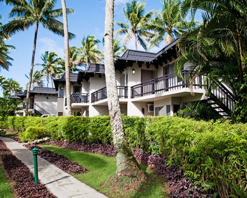 Scenic exterior view of the Fiji Palms surrounded by coconut trees.