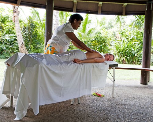 A man enjoying a massage at the outdoor spa area.