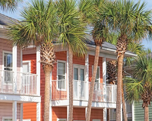 An exterior view of multi story resort units with trees.