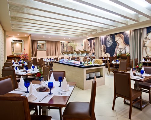 A restaurant interior with multiple dining tables and buffet.