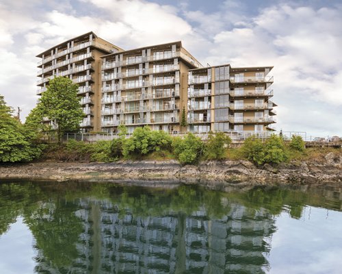 An exterior view of multi story resort units with the waterfront.