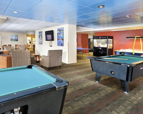 An indoor recreation area with two pool tables.