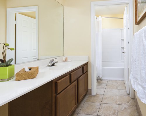 A bathroom with a closed sink vanity and bathtub.