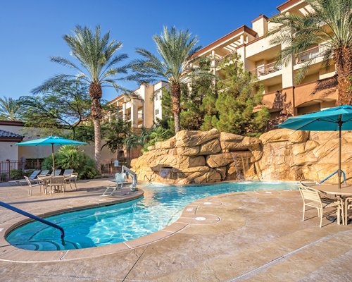 A view of grotto pool with patio furniture and chaise lounge chairs.