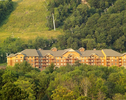 Exterior view of Kaatskill Mountain Club surrounded by wooded area.