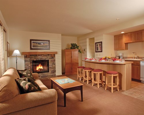 An open plan living room with a fire in the fireplace kitchen and breakfast bar.