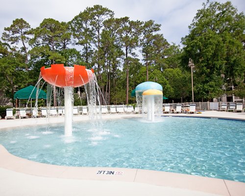 Large outdoor swimming pool with raining mushroom umbrellas.