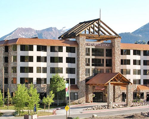 Exterior view of Grand Lodge Crested Butte alongside the mountains.
