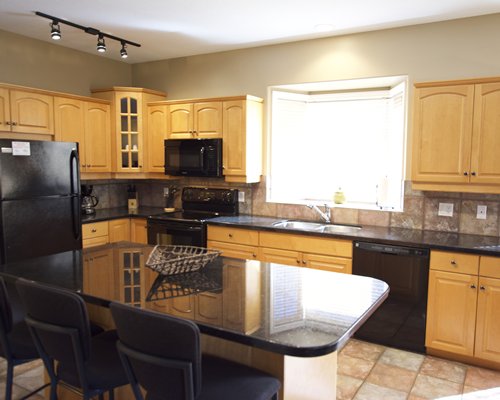 A well equipped kitchen with breakfast bar and microwave.