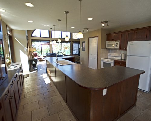 A well equipped kitchen alongside the living area with an outside view.