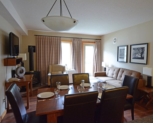 An open plan living and dining area with a television and an outside view.