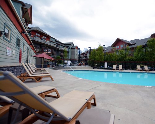 An outdoor swimming pool with chaise lounge chairs.