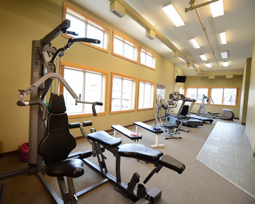 A well equipped indoor fitness center with an outside view.