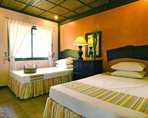 A well furnished bedroom with two twin beds and outside view.