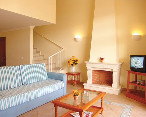 A well furnished living room with a television fireplace and stairway.