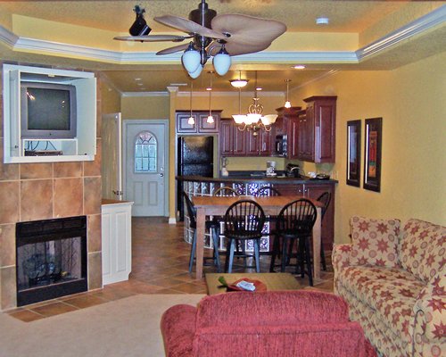 A well furnished living room with a television fireplace dining area and open plan kitchen.
