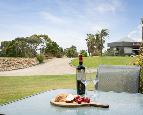 A WELL MAINTAINED GOLF COURSE WITH TREES ALONGSIDE THE RESORT UNIT.