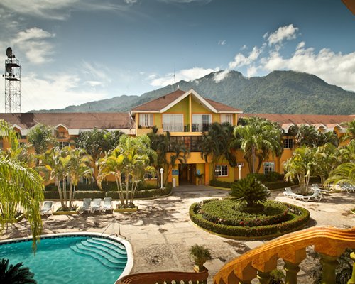 An exterior view of the resort units with trees and a swimming pool.