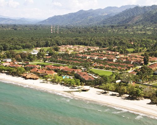 An aerial view of the resort property surrounded by wooded area alongside the beach.