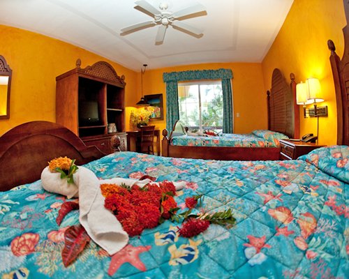 A well furnished bedroom with two queen beds and an outside view.
