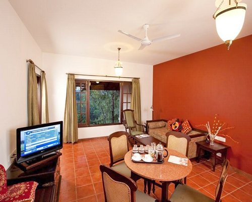 A well furnished living and dining area with a television and an outside view.