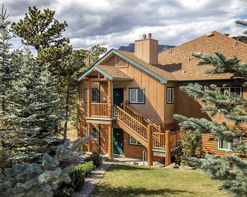 Scenic exterior view of multi story resort units with trees.