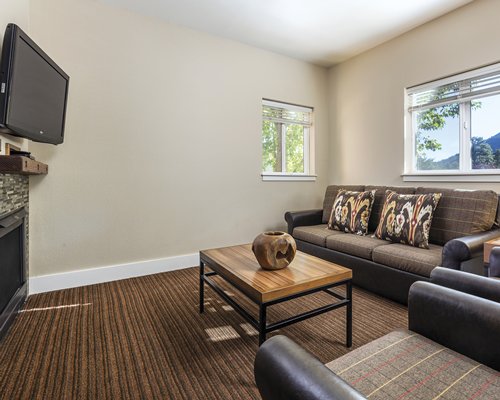 A well furnished living room with a television fireplace and outside view.