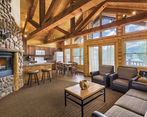 An open plan living dining and kitchen area with a breakfast bar and fireplace.