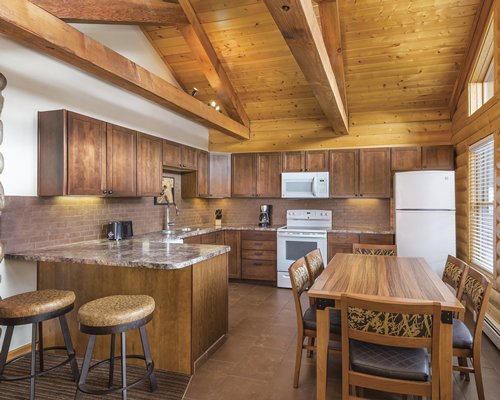 An open plan kitchen with dining area breakfast bar and outside view.