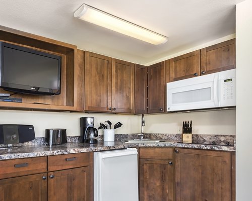 A well equipped kitchen with a television.