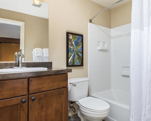 A bathroom with bathtub and single sink vanity.