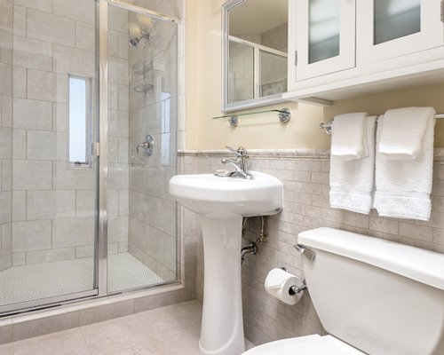 A bathroom with a stand up shower and single sink vanity.