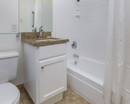 A bathroom with a closed sink vanity and bathtub.