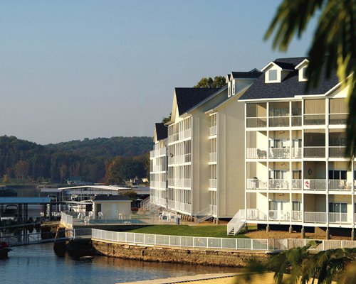 Scenic exterior view of Westside Bay Resort with multiple balconies and bridge at the lake.