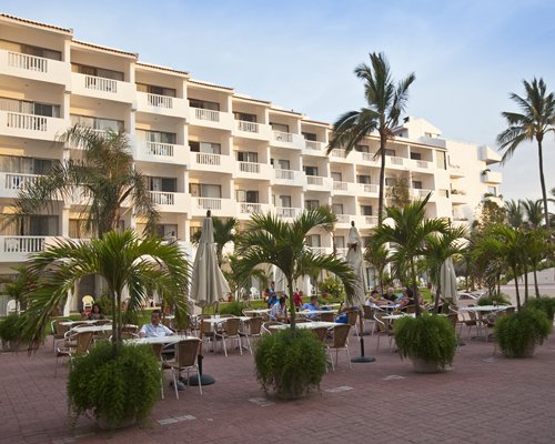 Scenic exterior view of Marival Resort & Suites with multiple balconies and outdoor restaurant.