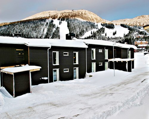 Exterior view of a unit covered with snow alongside mountains.