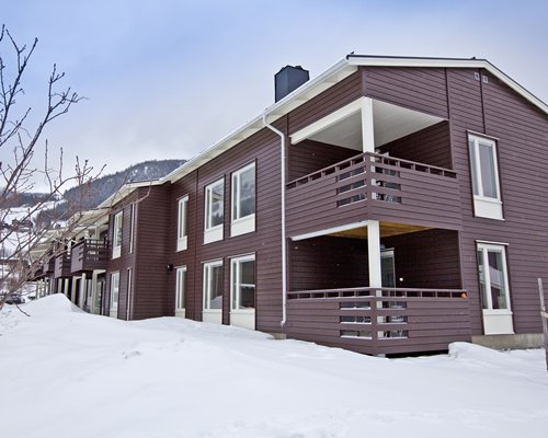 An exterior view of multi story resort units covered in snow.